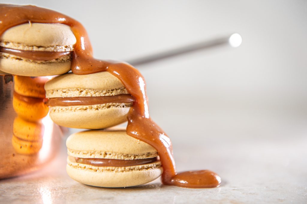 A stack of macarons topped with oozy,creamy salted caramel filling
